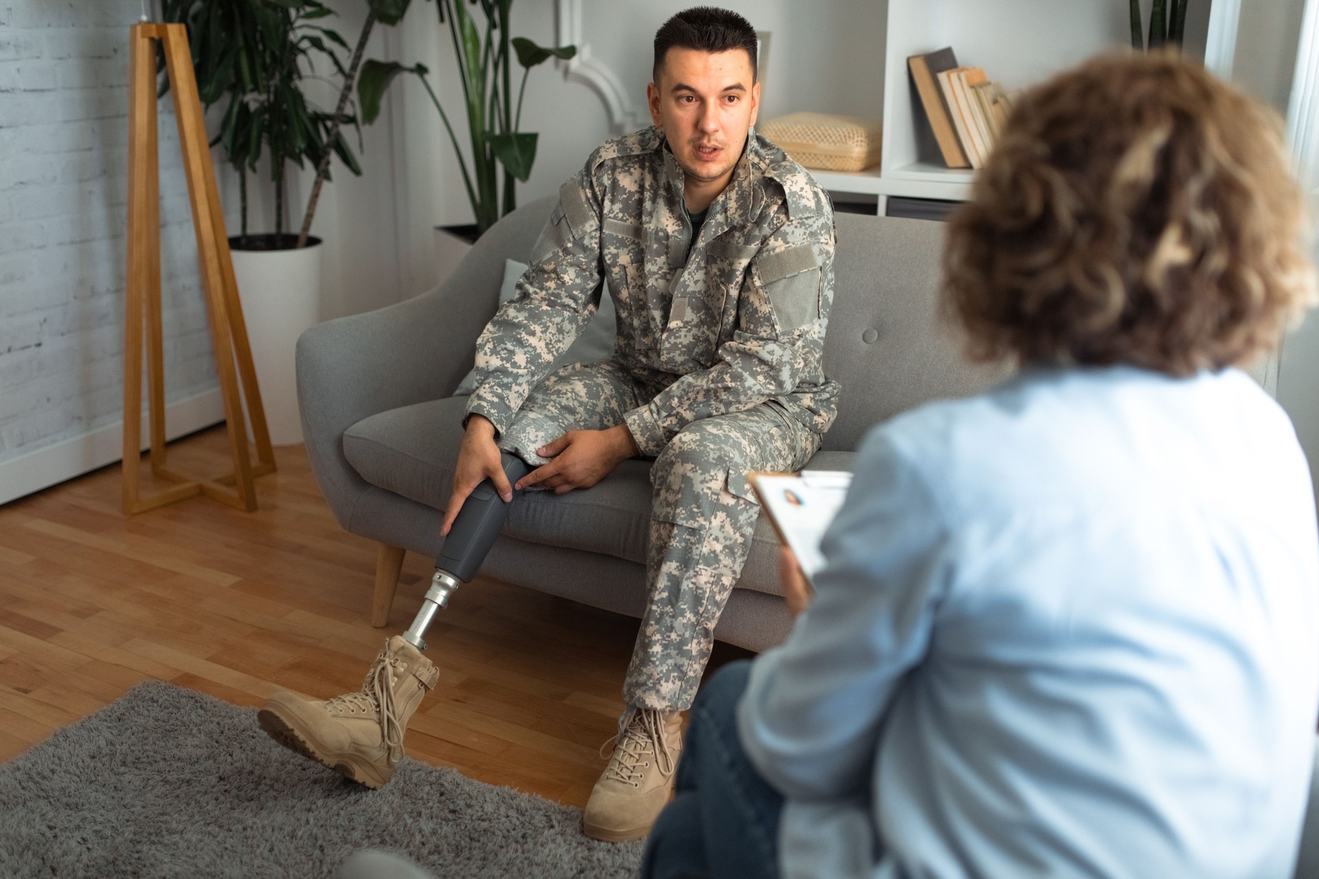 Soldier with prosthetic limb talking with therapist.